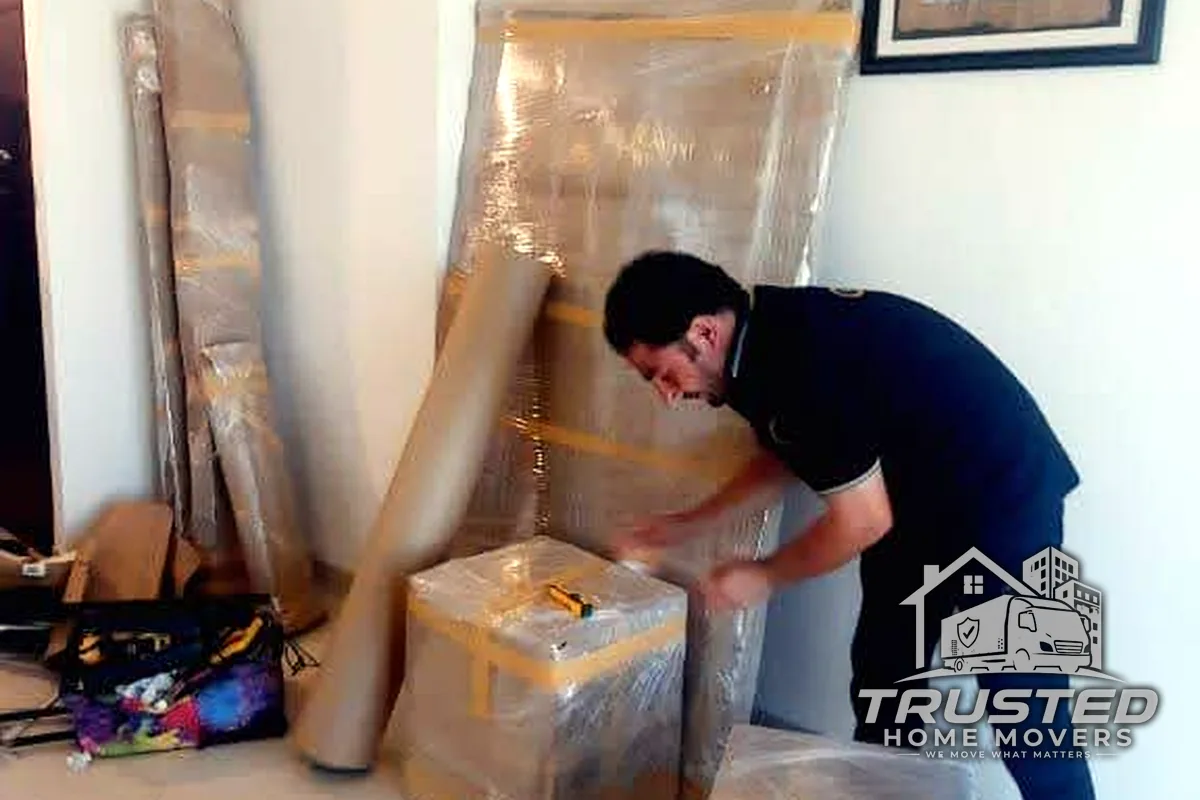 A Trusted Home Movers packer carefully taping a box